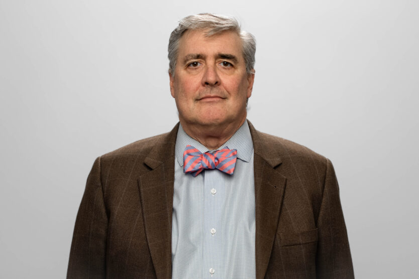 A man in a suit and bowtie looks at the camera.