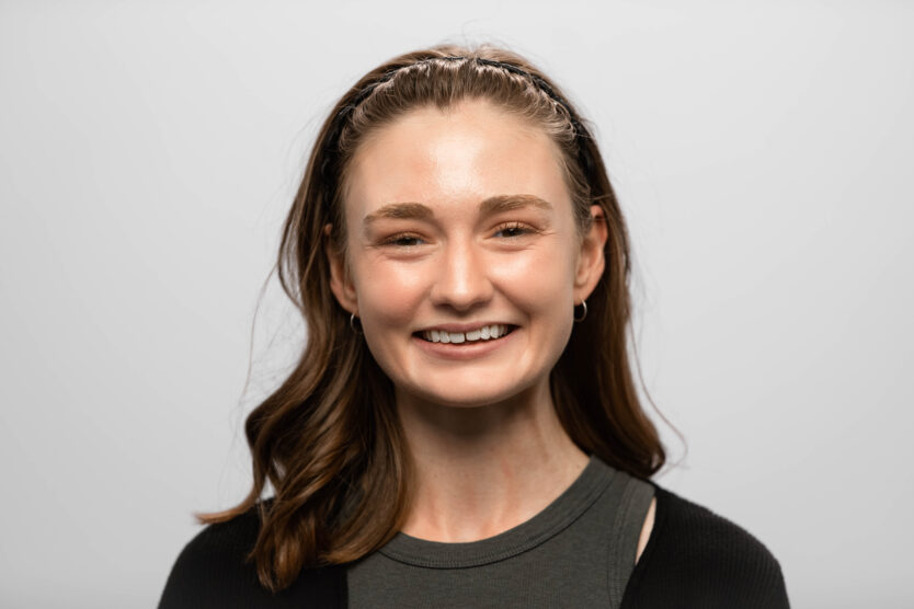 A woman with shoulder-length hair smiles at the camera.