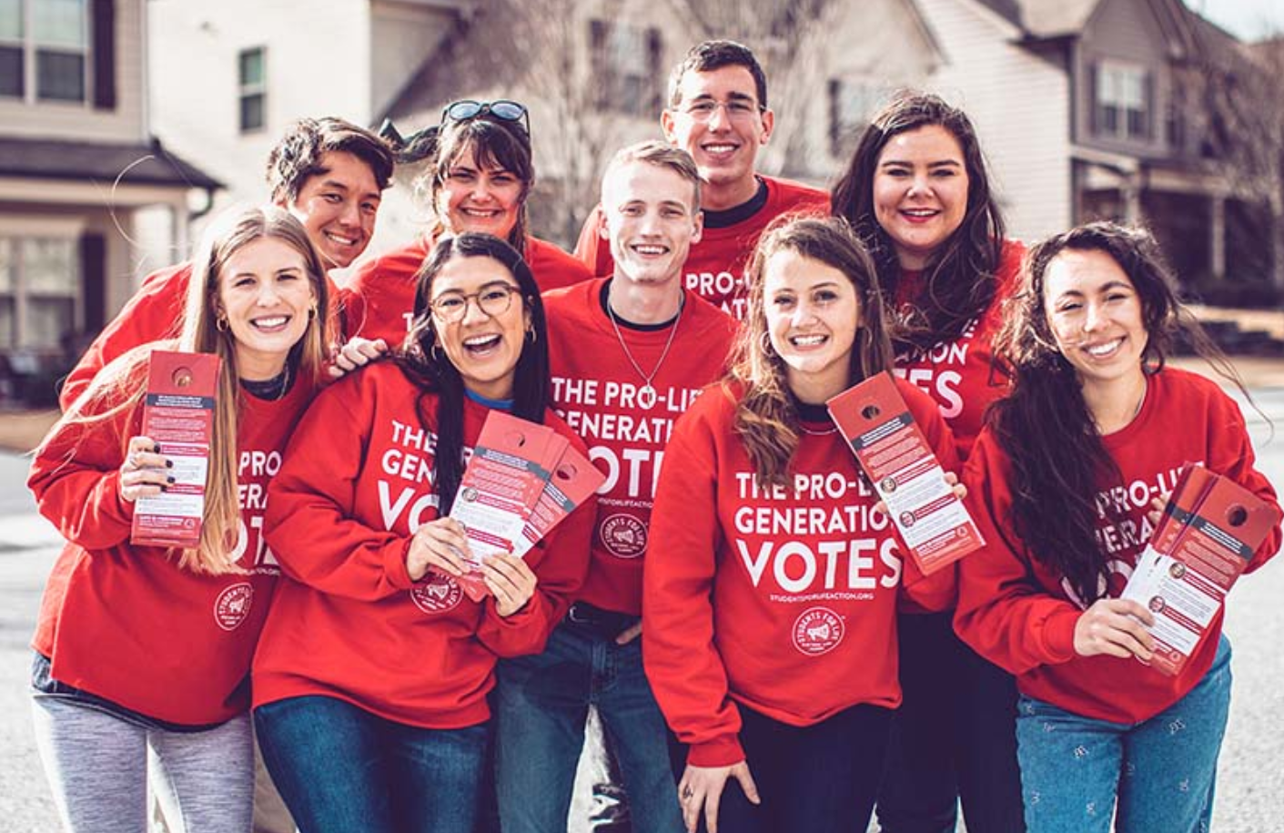 A group of people wearing matching outfits pose for a photo.