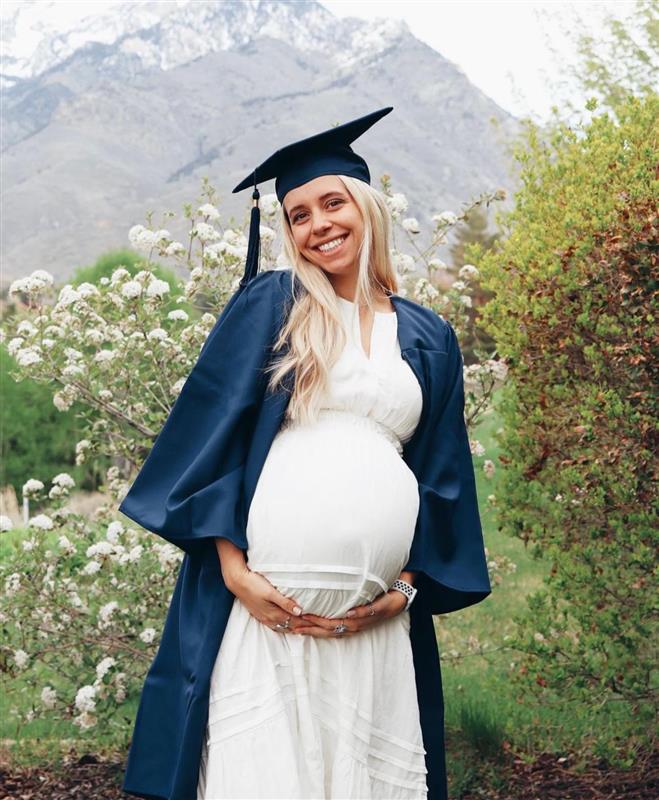 A pregnant student in a graduation cap and gown